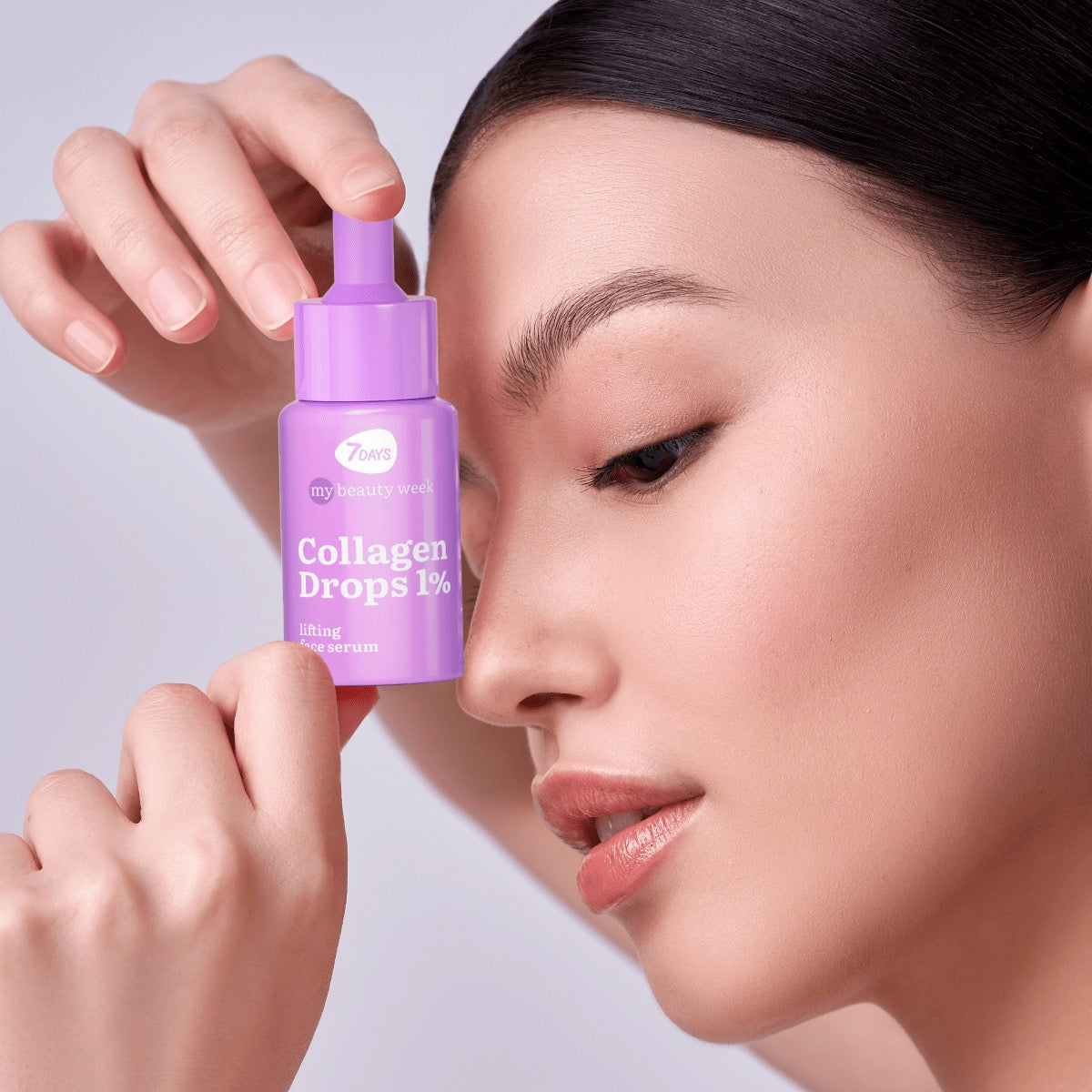 rau mit glatter Haut hält ein lilafarbenes Fläschchen 7DAYS my beauty week Collagen Drops 1% Lifting Face Serum an ihr Gesicht.