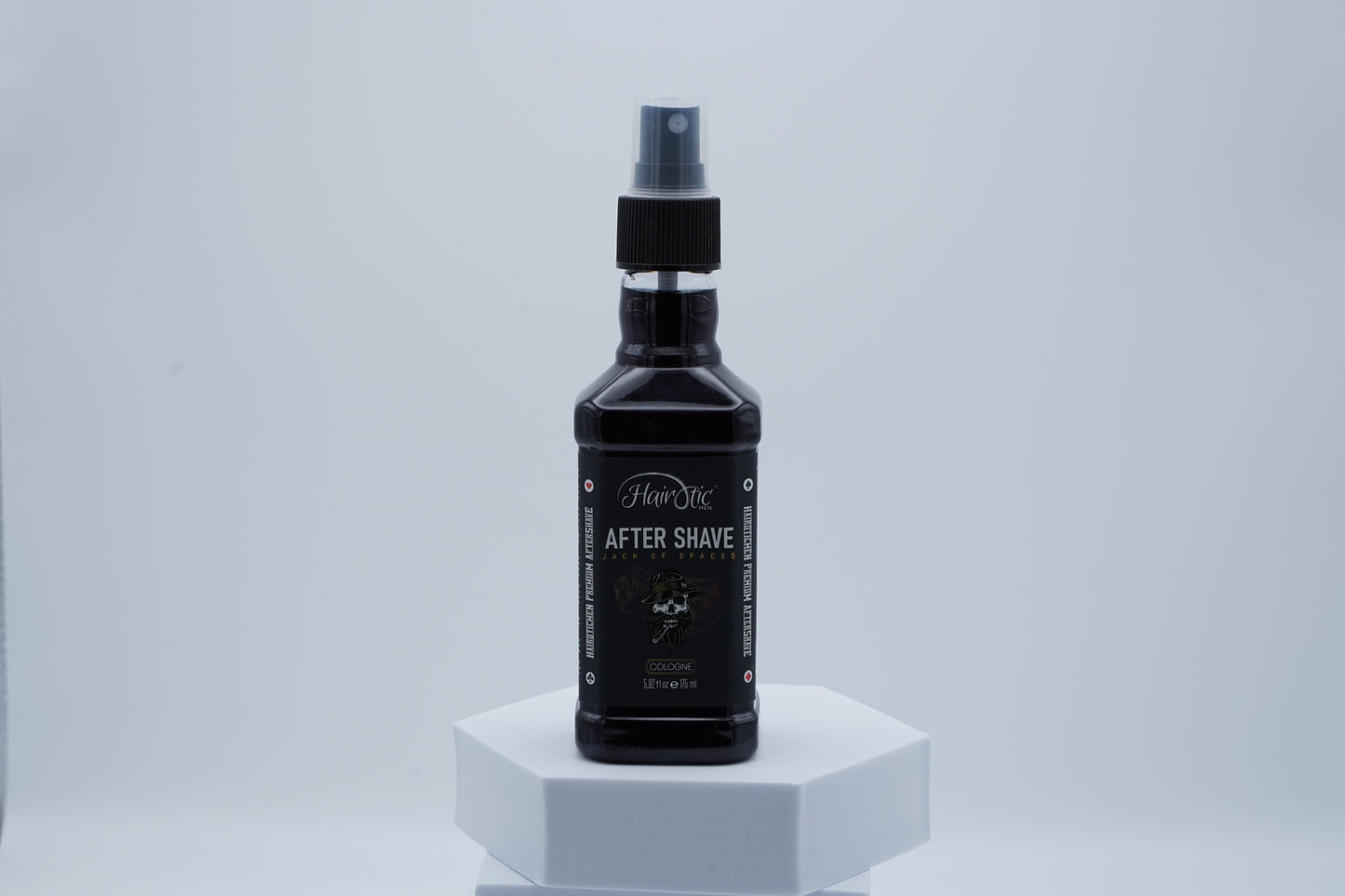 Schwarze Sprühflasche Hairotic After Shave Jack of Spades, platziert auf weißem Podest vor neutralem Hintergrund.