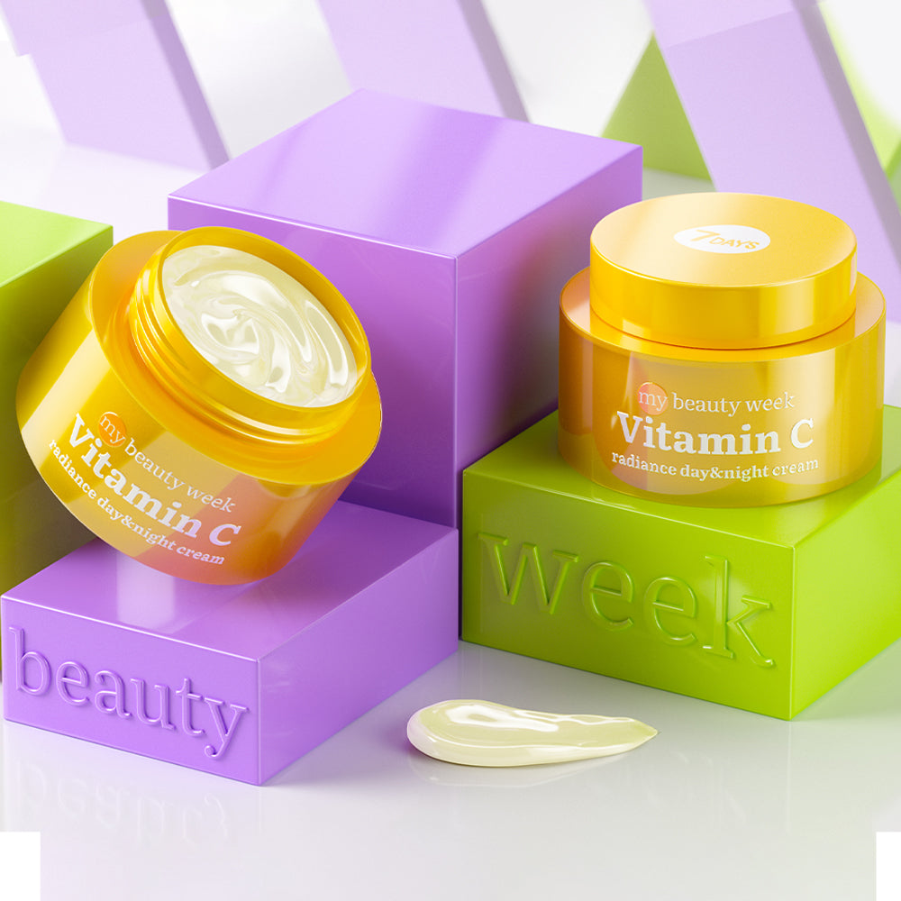 Offene und geschlossene Creme-Dose der 7DAYS my beauty week Vitamin C Radiance Day & Night Cream, dekorativ auf bunten Blöcken in Lila und Grün präsentiert, mit cremiger Textur vor der Verpackung.