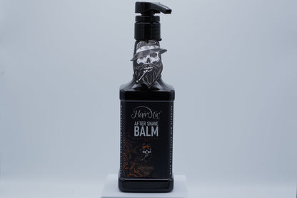 Schwarze Pumpflasche Hairotic After Shave Balm Adrenaline, mit Totenkopf-Logo, stehend auf weißem Podest vor neutralem Hintergrund.