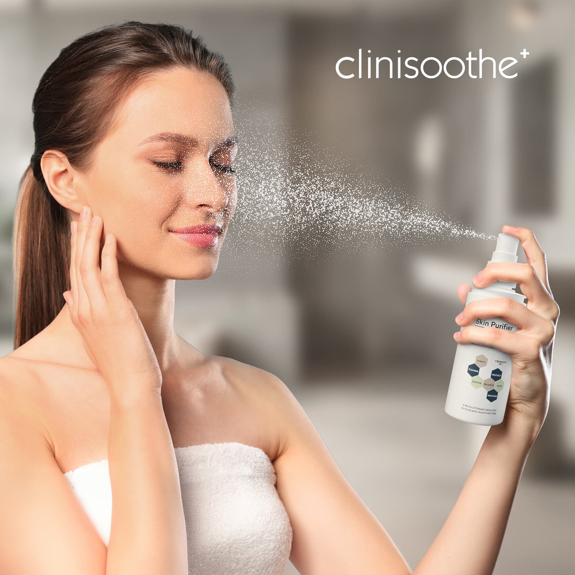 rau mit Handtuch um den Körper sprüht sich Clinisoothe Skin Purifier ins Gesicht. Feiner Sprühnebel verteilt sich auf der Haut, im Hintergrund unscharfer Badezimmer-Look.
