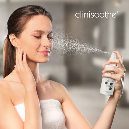 rau mit Handtuch um den Körper sprüht sich Clinisoothe Skin Purifier ins Gesicht. Feiner Sprühnebel verteilt sich auf der Haut, im Hintergrund unscharfer Badezimmer-Look.