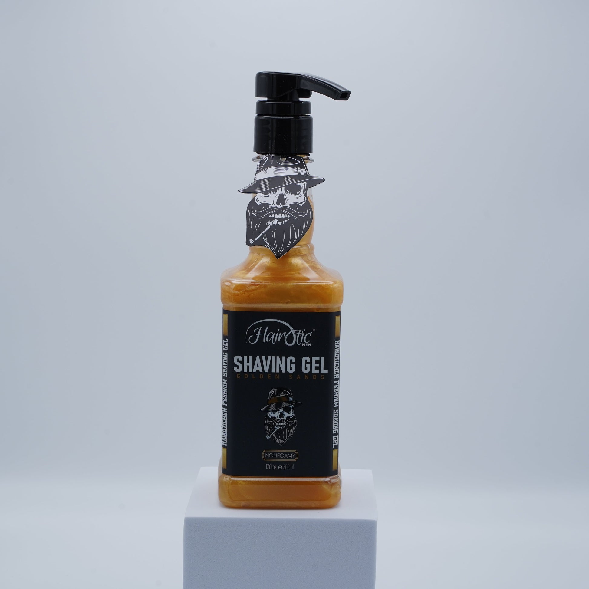 Hairotic Shaving Gel Golden Sands in goldener Flasche mit Pumpspender und Totenkopf-Design auf grauem Podest.
