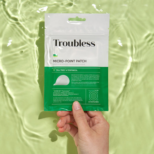 Troubless Micro-Point Patch – Hand hält Verpackung über Wasser, 9 Hydrocolloid-Pflaster mit Mikronadeln für punktgenaue Anwendung
