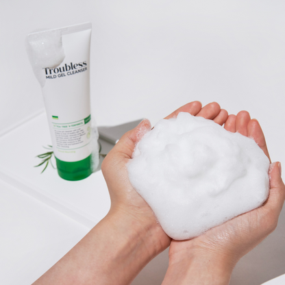 Troubless Mild Gel Cleanser – reichhaltiger Schaum in den Händen, Tube im Hintergrund sichtbar
